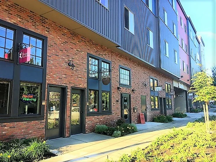 Exterior photograph of the front view of a four story building on a sunny day.